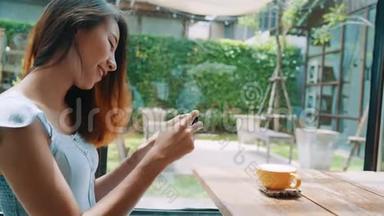 一位年轻女士在智能手机上拍摄咖啡茶，用手机相机拍摄餐品。